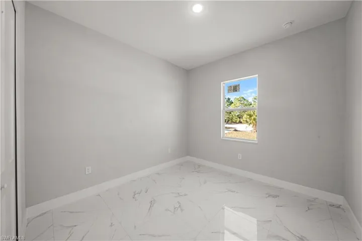 Spare room featuring marble finish floor and baseboards