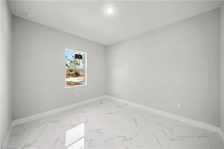 Unfurnished room featuring baseboards and marble finish floor