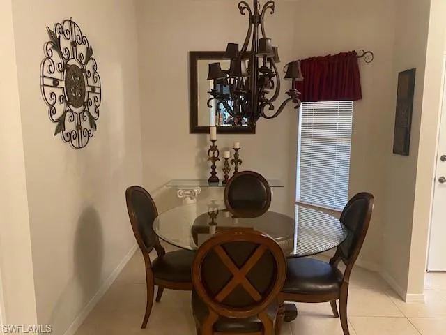 Tiled dining room with a notable chandelier