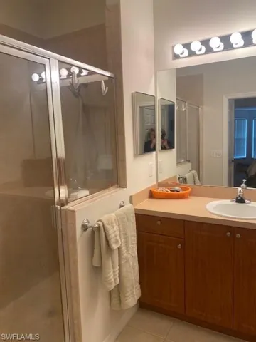 Bathroom featuring vanity, an enclosed shower, and tile patterned flooring