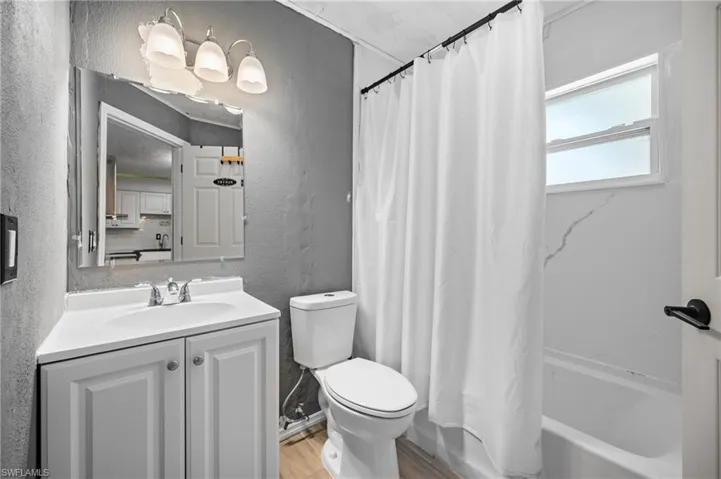 White vanity with a single basin sink, chrome faucet, and storage cabinetry