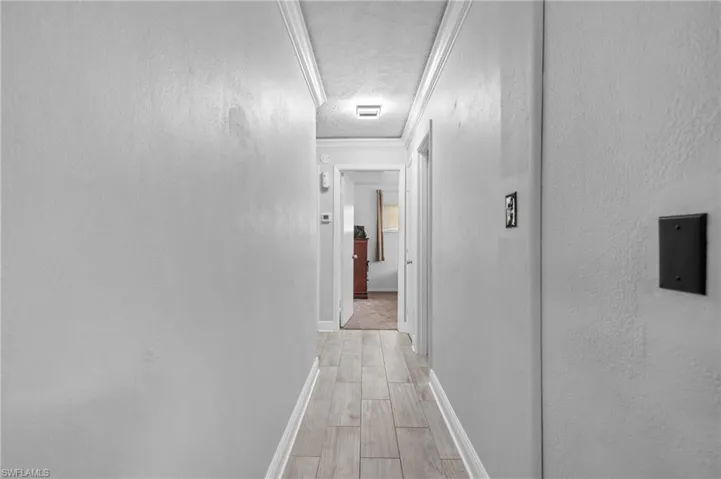 Hallway featuring wood-finish flooring, light-toned walls, and recessed lighting