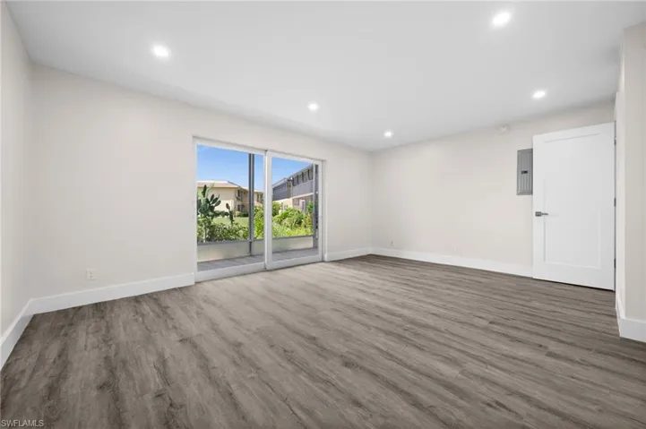 Unfurnished room featuring recessed lighting, wood finished floors, and electric panel