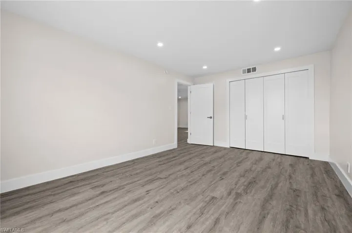 Unfurnished bedroom featuring wood finished floors, recessed lighting, and a closet
