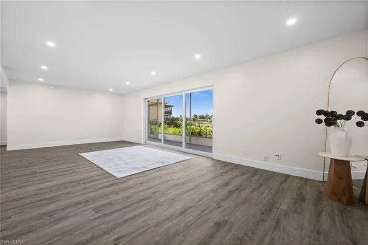 Unfurnished living room featuring recessed lighting and dark wood-style flooring