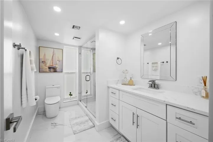 Full bathroom with vanity, a stall shower, recessed lighting, and light marble finish flooring