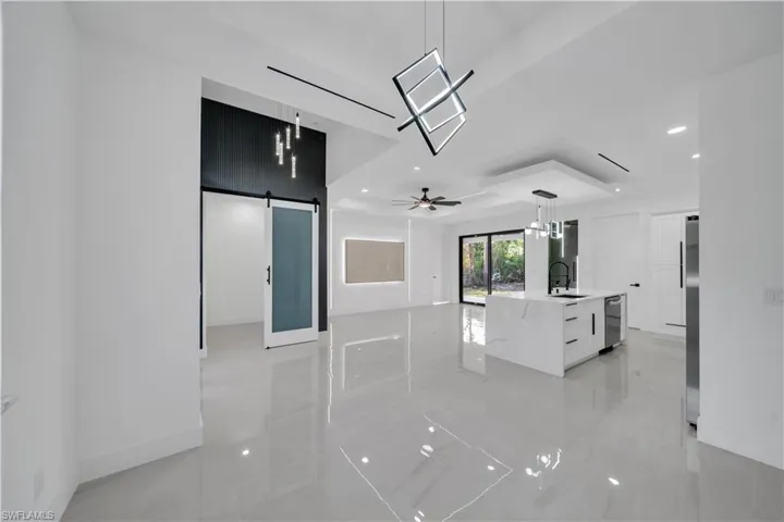 Kitchen featuring dishwasher, modern cabinets, a barn door, a sink, and fridge