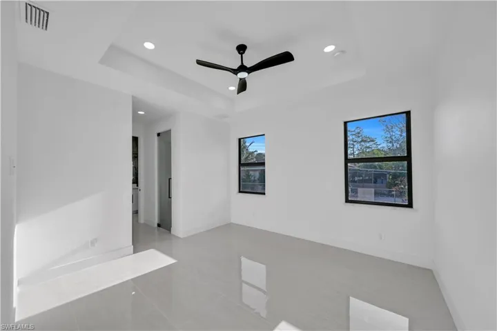 Empty room featuring baseboards, visible vents, and a raised ceiling