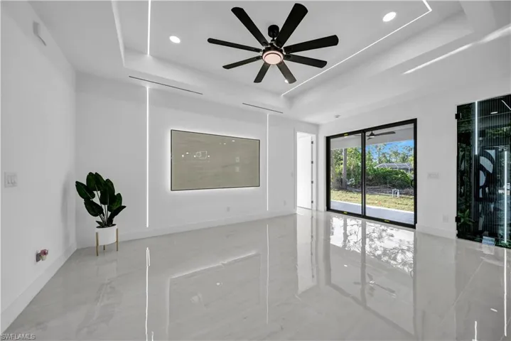 Unfurnished room with a tray ceiling, baseboards, ceiling fan, and recessed lighting