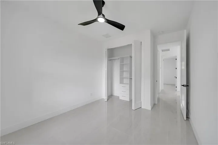 Unfurnished bedroom with a closet, visible vents, baseboards, and a ceiling fan