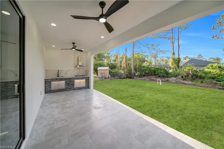 View of patio with a ceiling fan, a sink, and area for grilling