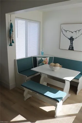 Built-in banquette seating with teal cushions and white wood-finish construction