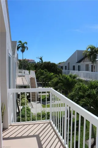 Private balcony with white railing overlooking tropical landscaping