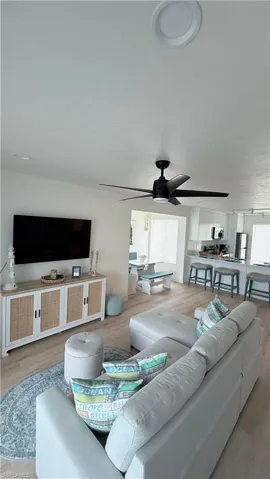 Open-concept living space featuring wood-finish flooring and a contemporary black ceiling fan