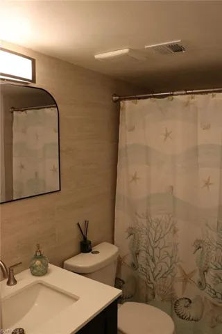 Bathroom featuring a built-in vanity with an undermount sink, a white countertop, and a brushed nickel faucet