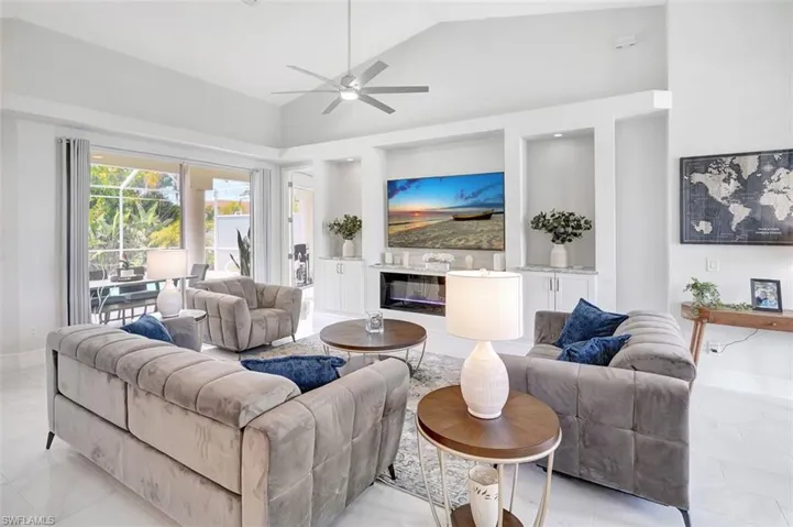 Living area featuring ceiling fan and high vaulted ceiling