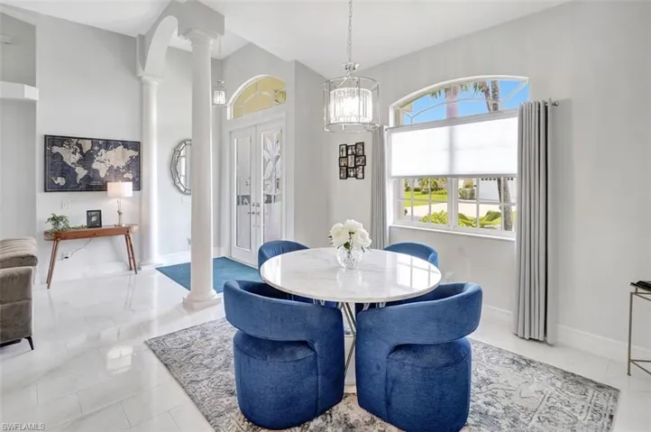 Dining room with ornate columns and baseboards
