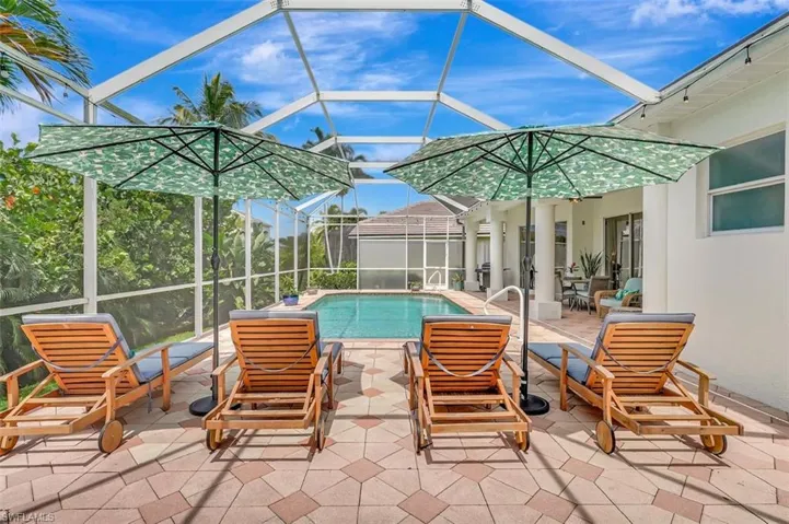 Swimming pool featuring glass enclosure and a patio area