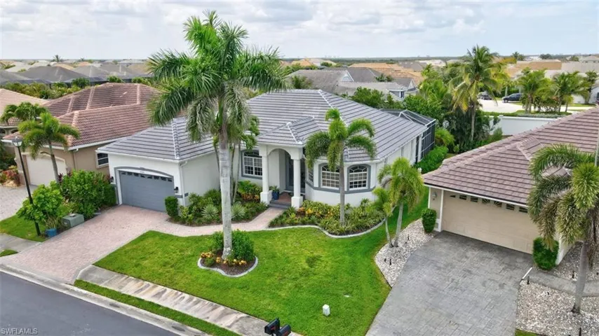 Single story home featuring a tile roof, decorative driveway, stucco siding, and a garage