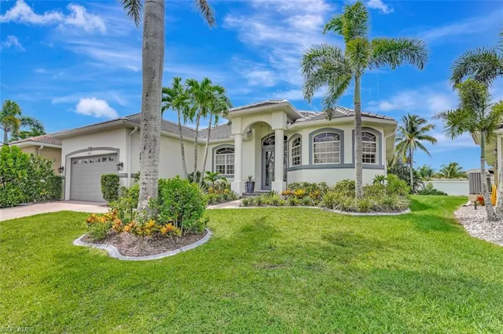 Mediterranean / spanish home featuring an attached garage, driveway, stucco siding, and a front lawn
