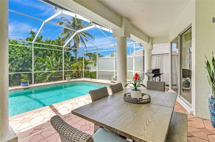 Swimming pool with a patio, glass enclosure, and grilling area