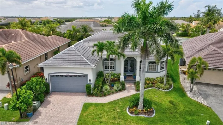View of front of home with french doors, stucco siding, a garage, a tiled roof, and driveway