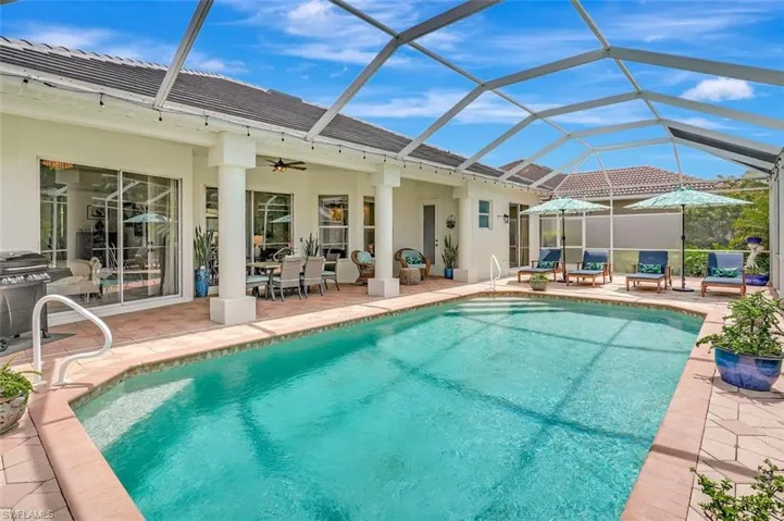 Swimming pool with a patio area, a ceiling fan, glass enclosure, and a grill