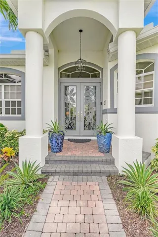 Entrance to property with french doors, stucco siding, and covered porch