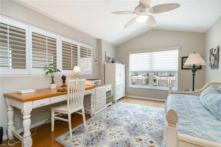 Den-Bedroom featuring light wood-type flooring, an office area, vaulted ceiling, and a ceiling fan