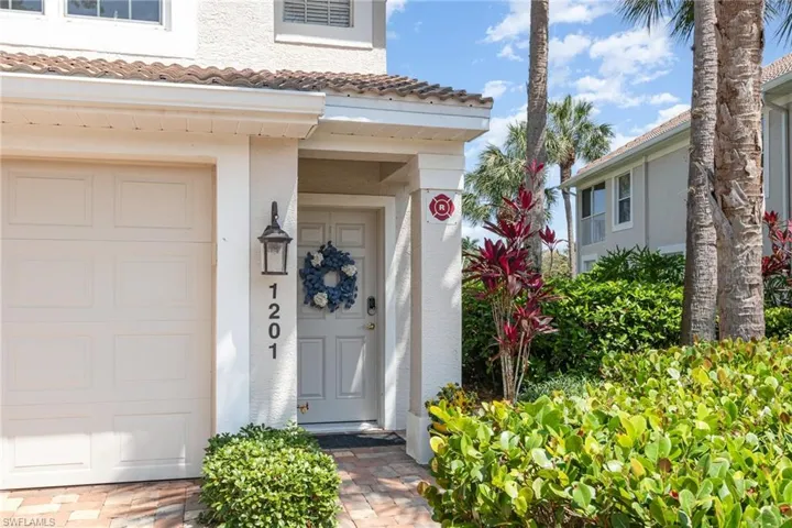 View of exterior entry with stucco siding, a garage, and a tiled roof