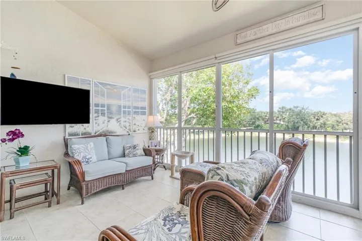 Sunroom / solarium featuring a water view, lofted ceiling, and outdoor lounge area