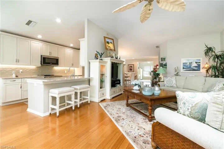 Living area with light wood finished floors, ceiling fan, and recessed lighting