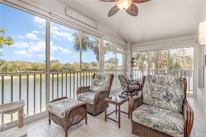 Sunroom with a water view, a ceiling fan, and vaulted ceiling