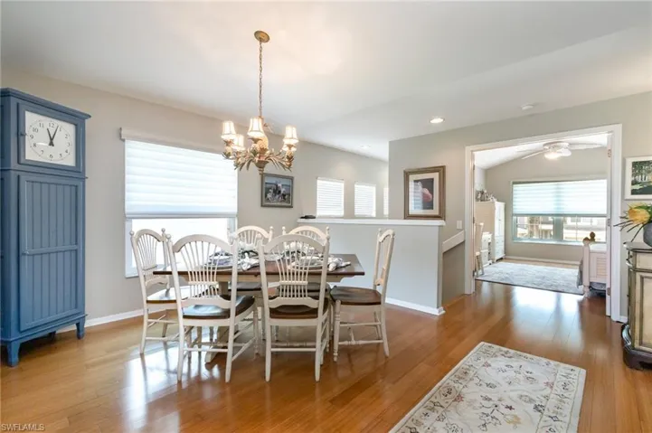 Dining area with a chandelier, baseboards, wood finished floors, a ceiling fan, and recessed lighting