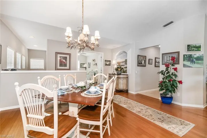 Dining area with wood finished floors, a chandelier, and baseboards