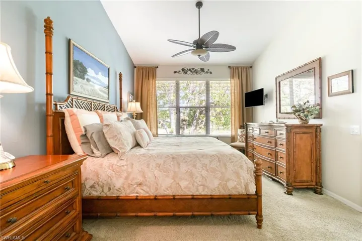 Primary Bedroom featuring light carpet, ceiling fan, and baseboards