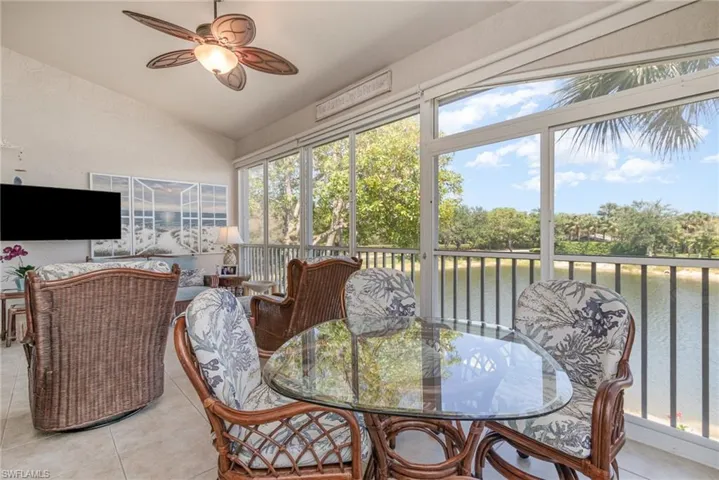 Sunroom / solarium with outdoor dining space, lofted ceiling, a water view, and a ceiling fan