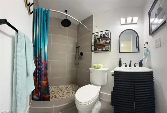 Bathroom featuring vanity and tiled shower