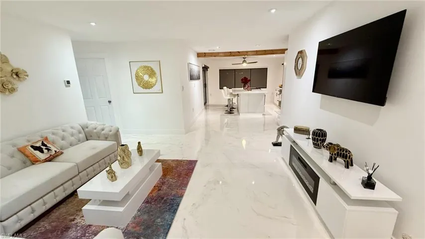 Living room with light marble finish floors and recessed lighting