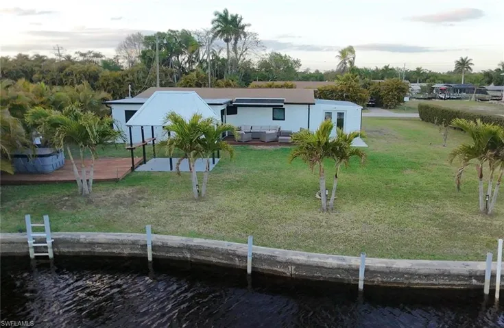 Rear view of property featuring a yard, a water view, a patio, and an outdoor hangout area