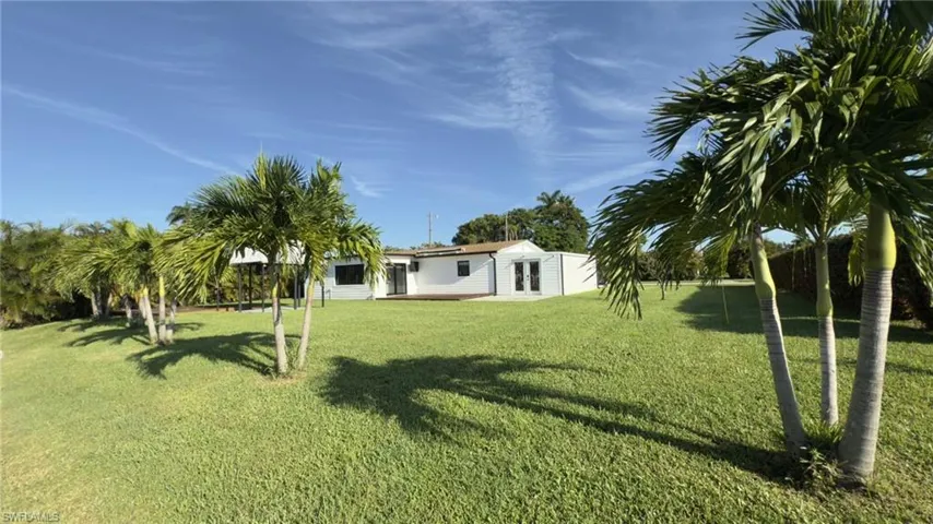 View of grassy yard with a patio area