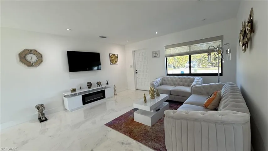 Living area featuring marble tiled floors and recessed lighting