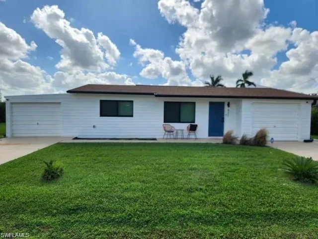 Ranch-style house with concrete driveway, an attached garage, and a front lawn