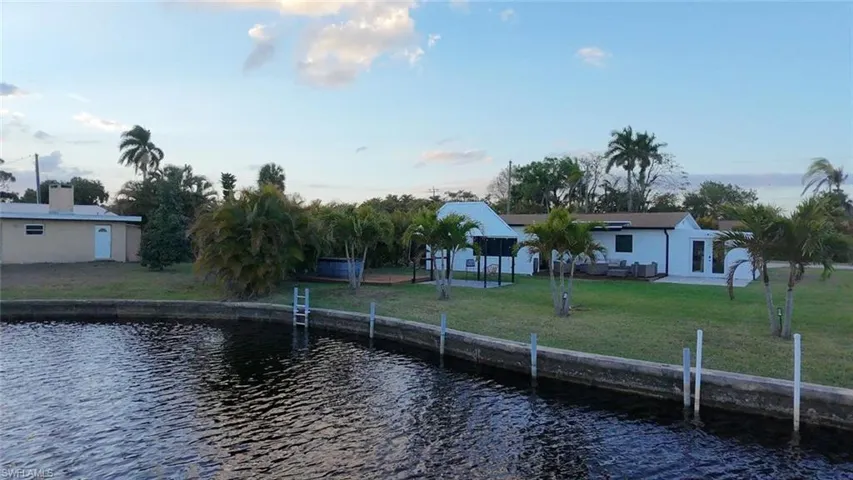 Dock with a water view, a yard, and a patio