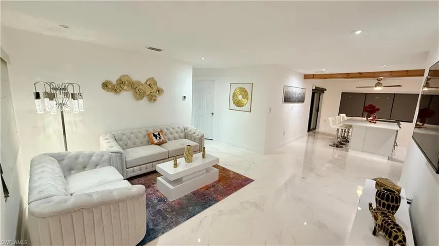 Living area featuring light marble finish floors, recessed lighting, and ceiling fan