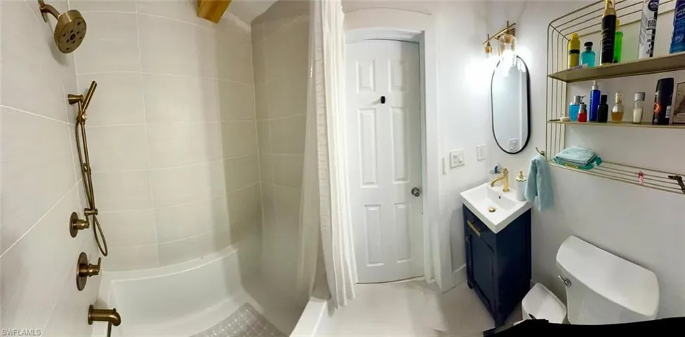 Full bathroom with vanity and curtained shower