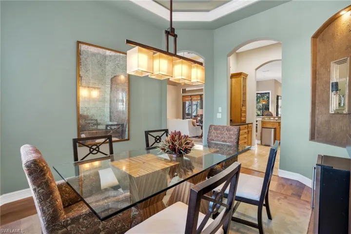 Dining room featuring arched walkways and wood finished floors