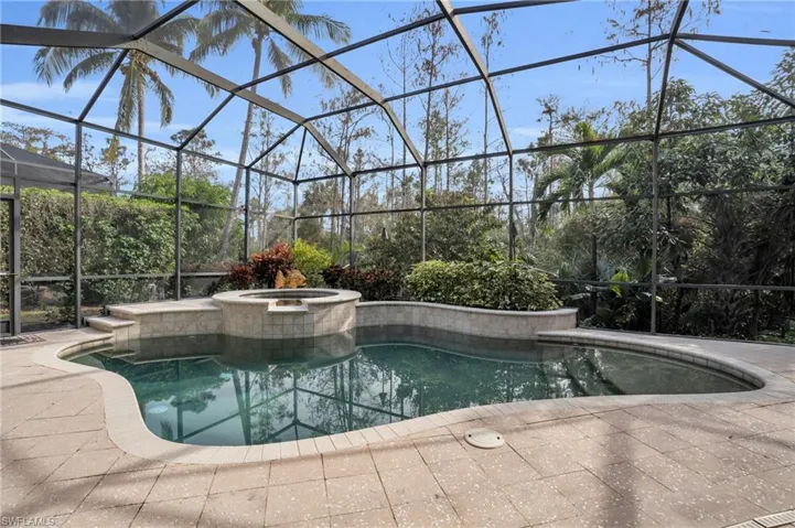 Relaxing pool / spa with a lanai and a sunroom