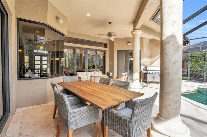 View of patio / terrace featuring an outdoor pool, a sunroom, glass enclosure, outdoor dining space, and a ceiling fan