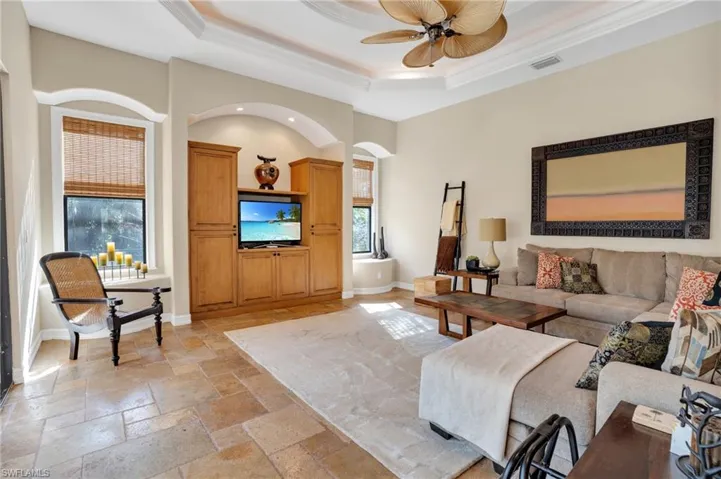 Living room with stone tile flooring and ceiling fan